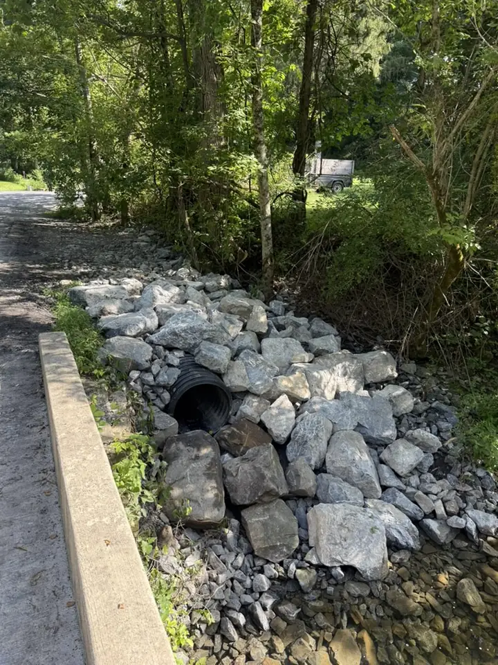 Stone riprap placed around a roadside culvert for drainage