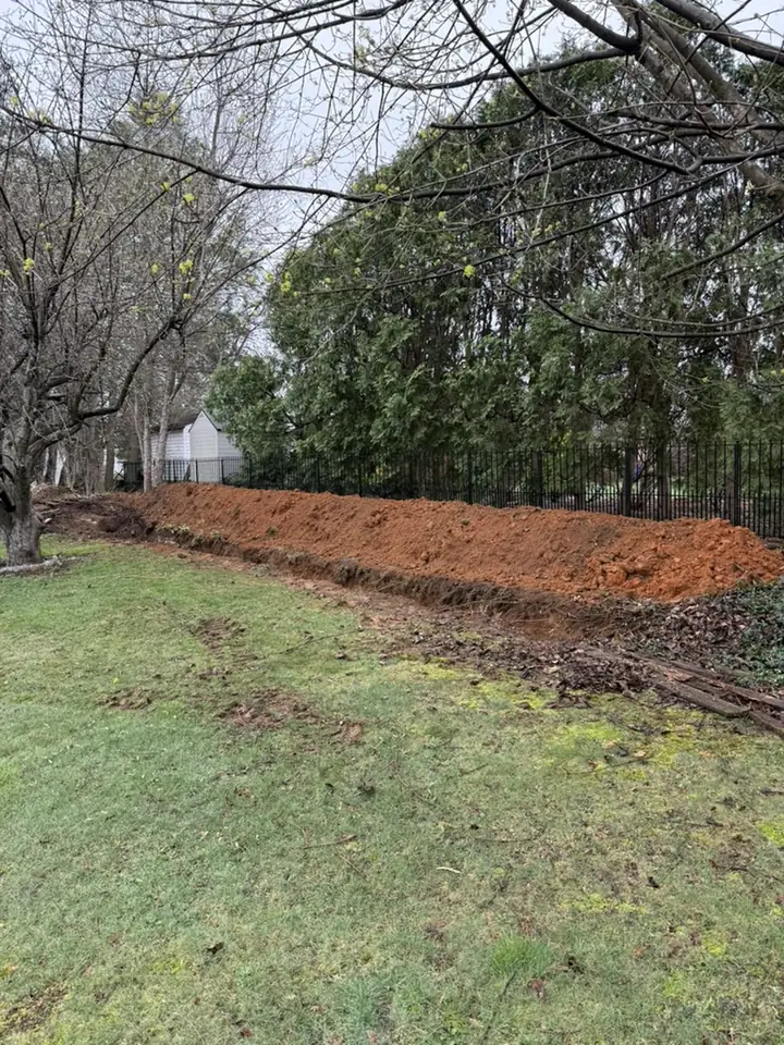 Backfilled drainage line running through a lawn