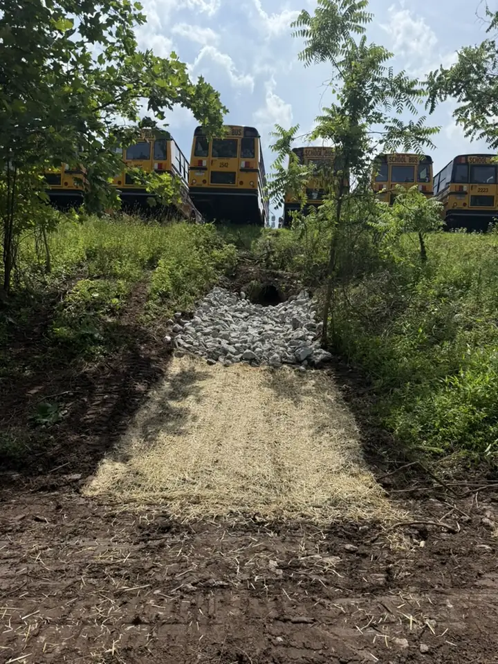 Drainage swale with erosion control matting and a rock outlet